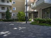 a paved brick street with red trash bins sitting in the middle and trees near to it