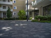 a paved brick street with red trash bins sitting in the middle and trees near to it