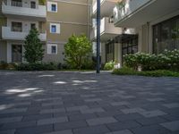 a paved brick street with red trash bins sitting in the middle and trees near to it