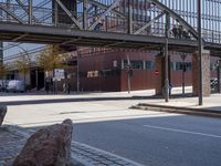 an empty city street with buildings and a truck on the side of it next to rocks