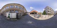 the view of a very wide city street taken from a fisheye lens looking at the buildings