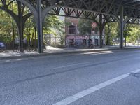 an empty city street, with a sign hanging off the side of it reads stop