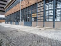 an old brick building with a metal gate that reads no parking and a black fire hydrant