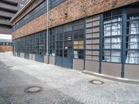 an old brick building with a metal gate that reads no parking and a black fire hydrant