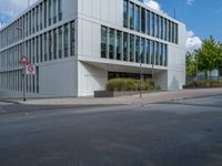 the building has a lot of glass windows on it, along with trees and bushes outside