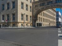 an archway with some windows to provide a light in the distance on a street corner