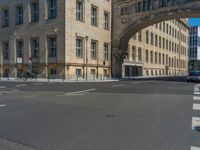 an archway with some windows to provide a light in the distance on a street corner