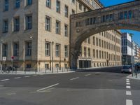 an archway with some windows to provide a light in the distance on a street corner