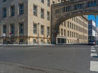 an archway with some windows to provide a light in the distance on a street corner