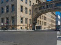 an archway with some windows to provide a light in the distance on a street corner