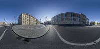 a panoramagraph image of an empty street and a building across from it, with two sides turned upward to the same direction