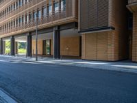 a road through which is a large modern building with an awning over it's entrance