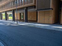 a road through which is a large modern building with an awning over it's entrance