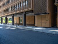 a road through which is a large modern building with an awning over it's entrance