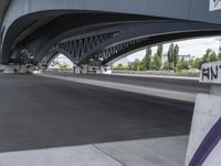 a very long cement road with some buildings and a few people on it, one is riding a skateboard