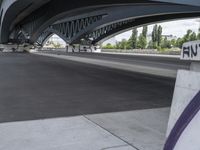 a very long cement road with some buildings and a few people on it, one is riding a skateboard