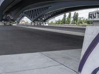 a very long cement road with some buildings and a few people on it, one is riding a skateboard