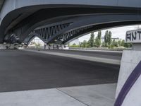 a very long cement road with some buildings and a few people on it, one is riding a skateboard