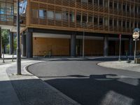 a road through which is a large modern building with an awning over it's entrance