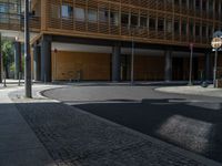 a road through which is a large modern building with an awning over it's entrance