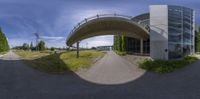 a 360 - image is of a bridge and a building in front of it with trees