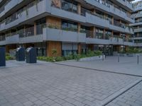 a courtyard of an apartment building with parking meters next to the walkways, and several balconies