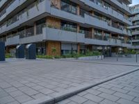 a courtyard of an apartment building with parking meters next to the walkways, and several balconies