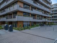 a courtyard of an apartment building with parking meters next to the walkways, and several balconies