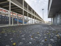 a long, empty walkway is leading to a building with parking lots on either side