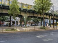 the train crossing over the overpass and in town is a pedestrian area near the road