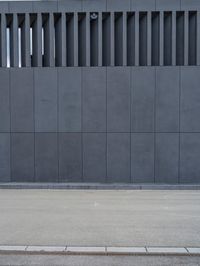 a yellow fire hydrant is sitting next to a gray building while a third hydrant sits near by