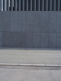 a yellow fire hydrant is sitting next to a gray building while a third hydrant sits near by