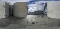 a view through a spherical object to another building with two circular columns and one building