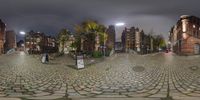 a large street with a lot of cobblestone streets and a tall building in the background