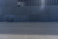 a person wearing a face mask walking across an empty street with a skateboard in the foreground