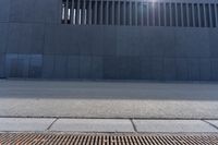 a person wearing a face mask walking across an empty street with a skateboard in the foreground