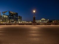 the city skyline is at night from the street level with traffic and pedestrians walking on it