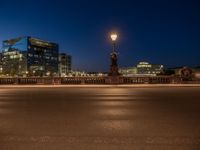 the city skyline is at night from the street level with traffic and pedestrians walking on it