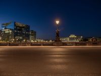 the city skyline is at night from the street level with traffic and pedestrians walking on it