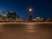 the city skyline is at night from the street level with traffic and pedestrians walking on it