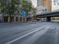 a city street that has a bridge over the road at sunset on a clear day