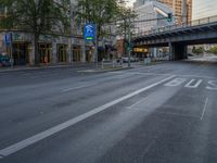 a city street that has a bridge over the road at sunset on a clear day