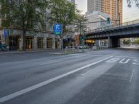 a city street that has a bridge over the road at sunset on a clear day