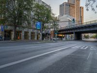 a city street that has a bridge over the road at sunset on a clear day