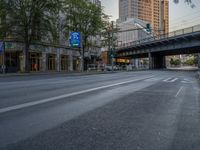 a city street that has a bridge over the road at sunset on a clear day