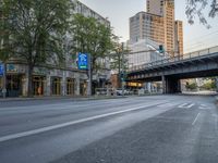 a city street that has a bridge over the road at sunset on a clear day