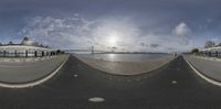 an upside down picture shows the street in front of the bridge and ocean with clouds in the sky