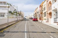 a car is parked on the street outside of some buildings in the street area with a red car on the right side