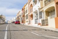 a car is parked on the street outside of some buildings in the street area with a red car on the right side