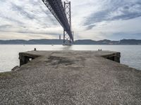 a view of the bay under a bridge from a pier in front of the ocean